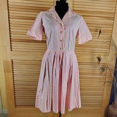 Lovely Pink Stripe Shirtwaist Dress With Short Cuffed Sleeves. Buttons To The Waist, Lace Trim, Pleated Skirt And Deep Hem. Possibly Home Sewn And Very Well Done. Label - No Label Color - Pink And White Size - Medium (Vintage Sizes Are Different So Please Check The Measurements) Measurements : Chest - 21 (Pit To Pit) Waist - 16 (Side To Side) Hips - Full Shoulders - 15 Sleeve - Length - 43 (Shoulder To Hem) Fabric - Cotton Blend Condition - Never Worn Or Washed Please Give Yourself Room For Move Spring Vintage Short Sleeve Lined Dress, Feminine Vintage Short Sleeve Dress For Daywear, Spring Vintage Dress With Short Sleeves And Lining, Feminine Short Sleeve Vintage Dress For Daywear, Fitted Striped Shirt Dress For Daywear, Casual Pink Short Sleeve Vintage Dress, Casual Pink Vintage Dress With Short Sleeves, Vintage Short Sleeve Shirt Dress For Spring, Spring Vintage Short Sleeve Shirt Dress