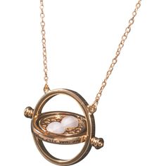 a gold necklace with a white stone in the shape of a wheel and two balls on it