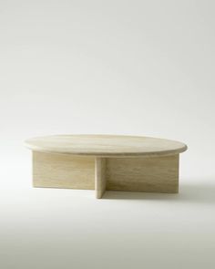 a round wooden table sitting on top of a white floor