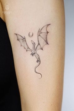 a woman's arm with a dragon tattoo on the left side of her body