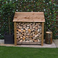 a pile of logs sitting next to a black trash can