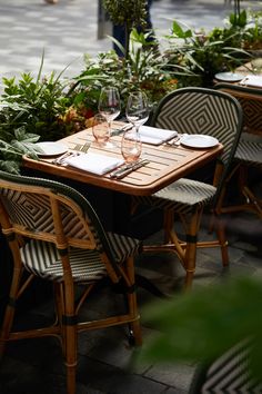 the table is set with wine glasses and place settings for two people to sit at