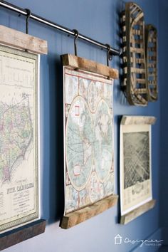 three framed maps hanging on the wall in front of a red and white postcard