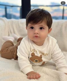 a little boy laying on top of a bed