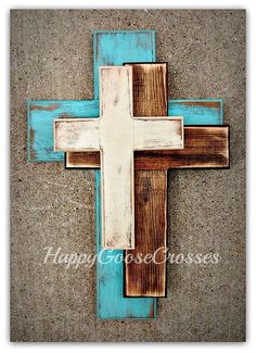 a wooden cross painted on the side of a building with blue and brown paint in it