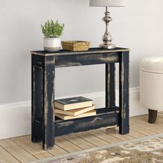 a table with books and a lamp on it in a room next to a rug