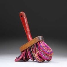 a pink and red brush with wooden handle