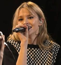 a woman holding a microphone up to her mouth