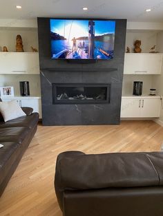 a living room with two couches and a flat screen tv mounted on the wall