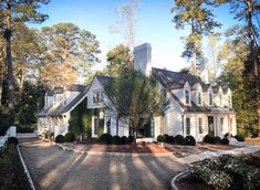 a large white house surrounded by trees and bushes