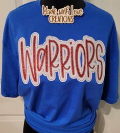 This listing is for a WARRIORS unisex shirt. This embroidered shirt comes in colors/fabric prints of your choice.  THIS LISTING IS ONLY FOR THE MASCOT SHIRT PICTURED AND LISTED ABOVE  OTHER MASCOTS ARE AVAILABLE PLEASE MESSAGE US OR BROWS OUR SHOP. IF THIS SHIRT IS ORDERED AND YOU PUT ANOTHER MASCOT NAME IT WILL BE CANCELLED. Feel free to request color changes. If you have no special requests, your design will resemble the first picture in the listing as closely as possible. Some fabrics in the applique design may differ slightly depending on availability of fabric. We use a mix of HTV glitter or glitter fabric and sequins on our designs.  We use unisex Gildan brand sweatshirts, Gildan softstyle t-shirt and Gildan long sleeve shirt for most orders we also use other brands when needed.  We Team-colored Tops With Embroidered Graphics For Fans, College Team Spirit Tops With Custom Embroidery, College Red Tops With Embroidered Text, Red College Tops With Embroidered Text, Red College Top With Embroidered Text, Red Embroidered Text College Tops, Embroidered School Spirit Tops For Game Day, School Spirit Embroidered Tops For Game Day, Team-colored Cotton Tops With Embroidered Graphics