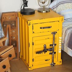 a yellow cabinet sitting on top of a wooden floor next to a bed and nightstand