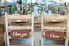 two wooden chairs sitting next to each other at a table with signs on them that say i love you, i know