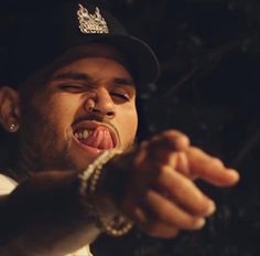 a close up of a person wearing a hat pointing at something with his mouth open