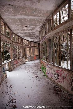 an abandoned building with lots of graffiti on the walls and windows that are covered in snow