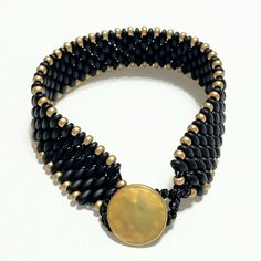 This unique 6 3/4 inch Central Florida football fan bracelet is hand woven in black and gold Czech glass beads.  There is a hammered golden button clasp, with a macrame loop closure. This hand made bracelet will make a great addition to your game day attire! This college pride bracelet can be made in other wrist sizes.  Please message me with your request. SIZE & DETAILS > 6 3/4 Hand woven beaded     college/university fan     bracelet > Matte black super duo     beads > Matte gold seed beads > Macrame Loop, Black And Gold Bracelet, Fan Bracelet, Florida Football, Super Duo Beads, Ucf Knights, Pride Bracelet, Duo Beads, Super Duo