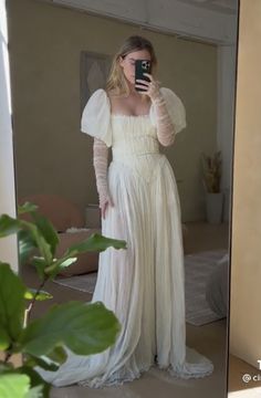 a woman in a white dress taking a selfie