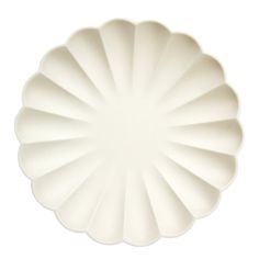 a large white plate with scalloped edges on a white background, viewed from above