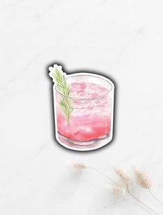 a pink drink in a glass with a sprig of rosemary