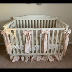 a white crib with pink bows on it