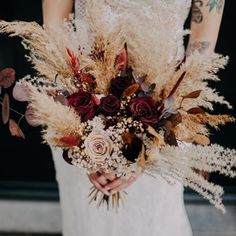 a bride holding a bouquet of dried flowers