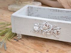 a white flower pot sitting on top of a wooden table