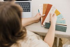 a woman sitting at a table with some books and a laptop on her lap top