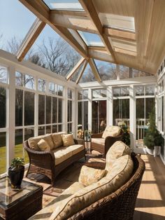 a sun room with wicker furniture and large glass windows on the ceiling is shown