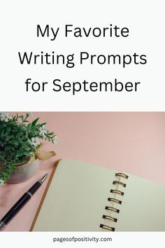 a notebook and pen sitting on top of a desk next to a potted plant