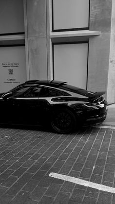 a black sports car parked in front of a building