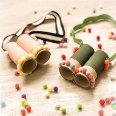 two rolled up paper tubes sitting on top of a table next to some sprinkles