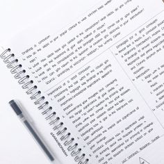 an open notebook with writing on it next to a pen