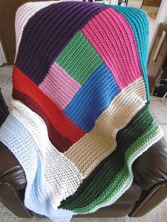 a crocheted blanket sitting on top of a leather chair