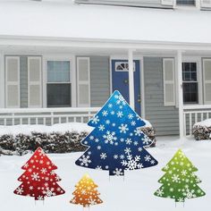 three christmas trees are in front of a house