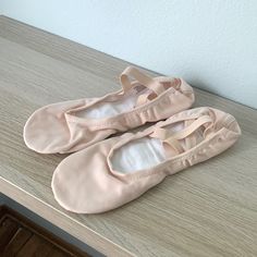 two ballet shoes sitting on top of a wooden table