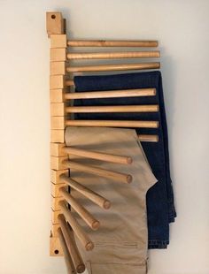 clothes hanging on the wall with wooden pegs attached to it's back pocket