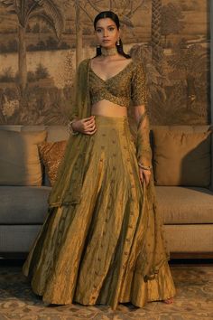 Moss green half sleeve padded blouse with antique gold cutdana, zardozi embroidery in scallop pattern. Paired with embroidered attached cancan lehenga and dupatta. 
Components: 3
Pattern: Embroidery
Type Of Work: Cutdana, zardozi, scallop
Neckline: Scallop V neck
Sleeve Type: Half sleeves
Fabric: Blouse and Lehenga: Tissue Silk, Dupatta: Net
Color: Green
Other Details: 
Model height: 5 ft 8 inches, wearing size XS
Lehenga:
Attached cancan
Length: 45 inches
Blouse:
Padded
Inverted V hem
Back tass Tissue Lehnga Design, Tissue Silk Lehenga Designs, Half Sleeves Blouse Designs Indian, Tissue Lehanga Design, Scallop Embroidery Dupatta, Traditional Lehenga Blouse Designs, Tissue Lehenga Designs, Tissue Fabric Lehenga, Velvet Lehenga Blouse