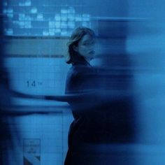 a blurry photo of a person in a blue room with a clock on the wall