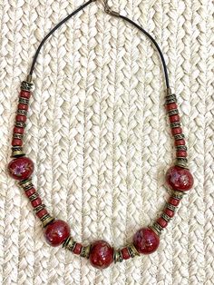 "Vintage 70s Handpainted glass bead and Leather Cord Brass Spacer Necklace Choker. measures 24\" long Good Vintage Condition" Bohemian Glass Jewelry With Single Strand, Bohemian Glass Single Strand Jewelry, Bohemian Single Strand Glass Jewelry, Artisan Adjustable Glass Beads, Adjustable Glass Beaded Necklaces With Wooden Beads, Red Glass Bohemian Necklace, Bohemian Glass Necklaces With Large Beads, Adjustable Czech Glass Necklace With Large Beads, Bohemian Glass Necklace With Large Beads