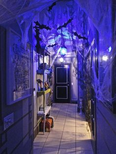 the hallway is decorated for halloween with purple lights and bats hanging from it's ceiling