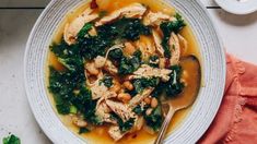 a white bowl filled with chicken and spinach soup