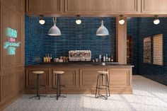 a blue tiled kitchen with stools and counter tops in the center, along with three lights on either side of the bar