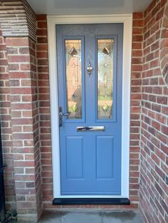 a blue front door with two sidelights and glass panels on the top half of it