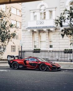 a red sports car parked in front of a tall building