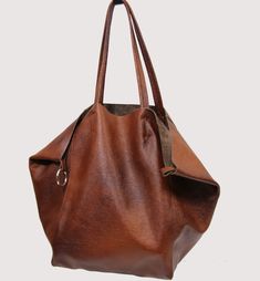 "Italian leather, genuine leather, metal hardware, natural leather, cowhide leather, cognac leather, brown leather, soft leather - Large, very roomy bag made of thick yet soft cattle leather. - Unlined, fastened with a keyring. - Additionally detachable leather cosmetic bag. Add this gorgeous bag to your collection!! Dimension details: Max width at the top: 60 cm / 23.6\" Height: 40 cm / 15.7\" Width at the base: 32 cm / 12.6\" Depth: 24 cm / 9.4\" Handle drop: 26 cm / 10\" Internal cosmetic bag Full Grain Leather Bag, Tan Leather Tote, Leather Cosmetic Bag, Large Leather Bag, Everyday Handbag, Large Leather Tote Bag, Small Leather Bag, Soft Leather Bag, Oversized Tote Bag