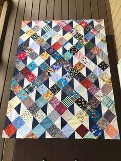 a multicolored patchwork quilt hanging on the side of a door