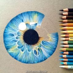 a drawing of an eye with colored pencils next to it