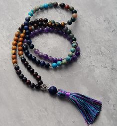 Mala Chakra Our Mala Chakra has arrived to harmonize all your chakras, elevate your energy, and fortify your innate spiritual talents. With 108 mala beads, each selected to correspond to and connect with one of the seven chakras, you can experience the energy flow from stones like amethyst, tiger's eye, jasper, onyx, agate, and wood. Brings a lapiz guru bead. This powerful mala meditation necklace is composed of an abundance of healing gemstones. Wear it to cleanse your chakras and align your bo Jasper And Amethyst, Mala Bead Necklace, Beads Mala, Tiger Eye Jewelry, Rose Quartz Jewelry, Bracelet Apple Watch, Jasper Jewelry, 108 Mala Beads, Chakra Necklace