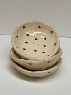 three bowls with red hearts on them are stacked in the shape of an elephant's head