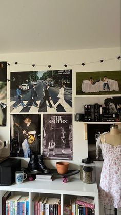 a room filled with lots of books and pictures on the wall next to a book shelf